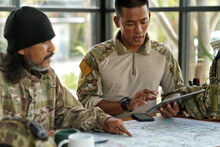 Army Ranger Special Force Discussion Looking Pointing At The War Map On Table And GPS To Mark Up Location Plan Before Attact Enemy
