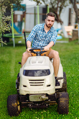 Wall Mural - Gardening details with worker using lawn tractor