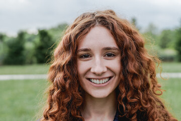 Happy ginger girl smiling on camera outdoor - Focus on face