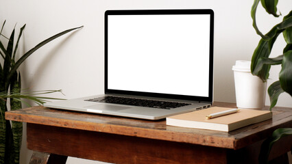 Laptop computer mock up. Workplace in scandinavian interior with green plants and wooden furniture.