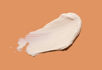 Poster - Cosmetic white mask or cleanser texture smudge swatch foam on peach orange background