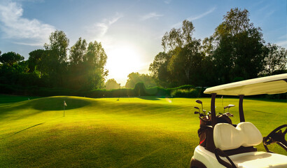 Wall Mural - Golf cart on beautiful golf course at sunset