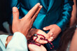 © mauro - a hand blessing a rosary over the hands of a couple