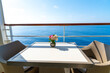 Flowers on a table for two on the balcony deck of a luxury cruise ship at sea on a sunny summer day.