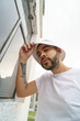 © Alejandro - young latin bearded man wearing a cap and white t-shirt, modern urban lifestyle, fashion and outdoor pose