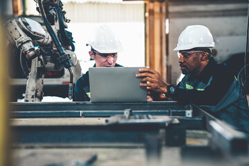 Wall Mural - Factory workers working with adept robotic arm in a workshop . Industry robot programming software for automated manufacturing technology .