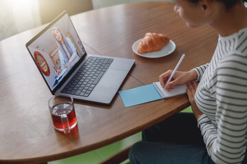 Wall Mural - top view of mixed-race female student having online video lesson with senior woman teacher