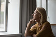 © fizkes - Pensive attractive middle-aged female resting on sofa at home looking out window having nostalgic mood, recollect, deep in thoughts, missing grown up children feeling loneliness. Retirement concept