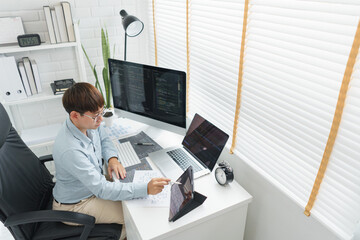 Wall Mural - software development concept, male programmer point data on tablet to checking website programming