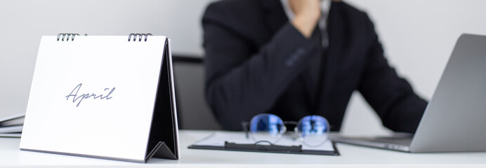 Asian man employee talking on the phone and working in a laptop with a smiling face, Office staff work and telephone conversations, Business conversation over the phone, handsome male in a black suit.