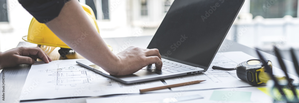 Foto Young man with a laptop plotting a system of building structures ...