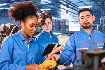 Wall Mural - Engineer senior asian man and african woman wearing safety helmet working and checking machine  automotive part warehouse. Factory for the manufacture and processing.