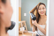 © Pormezz - Lifestyles domestic routine for women, Asian woman blowing hair with hairdryer at home.