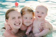 Mother And Kids Having Fun In The Swimming Pool. Summer Leisure And Family Holidays And Vacation Concept. People Swim In A Metal Frame Pool In The Backyard. Mom With Children: Baby Son And Daughter.