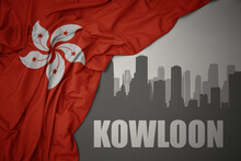 Abstract Silhouette Of The City With Text Kowloon Near Waving National Flag Of Hong Kong On A Gray Background.3D Illustration