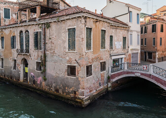 Beautiful view of a canal in Venice, Italy around sunset and traditional architecture on the background 