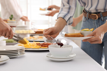 People near table with different dishes during breakfast, closeup. Buffet service