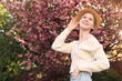 © New Africa - Beautiful teenage girl with hat near blossoming tree in spring