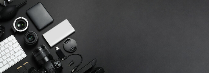 Wall Mural - flat lay composition with camera and video production equipment on black background, space for text.