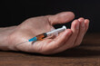 Addict man dead after inject drug overdose with syringe injection heroin to hand.