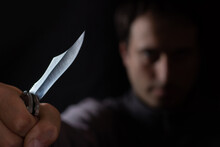 Knife In The Hand Of A Man. Threat With Knife. Man Attack With Knife. Crime, Violence. Selective Focus. Blurred Face.