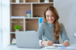 © amnaj - Asian businesswoman sitting happily working in the office