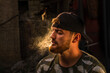 Handsome Young caucasian men, man with stubble beard, Portrait man with cigar and smoke isolated on black background serious man wearing t shirt in the countryside, bodybuilder,  Blond