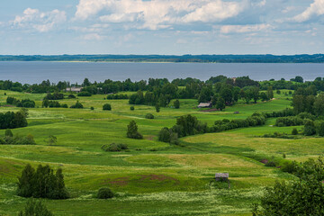 Wall Mural - A view from above to meadows, home, lake and horizon.