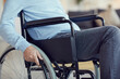 © Mediaphotos - Close-up of unrecognizable man in casual clothing sitting in wheelchair and turning wheels for motion