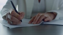 Businesswoman hand signing report in office closeup. Financial manager approving