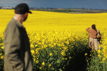 young father, mother and child daughter playing in the yellow rape fields. Family is having fun on the nature. Concept of friendly family and of summer vacation. Fathers day, mothers day and baby day