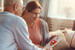 © Mediaphotos - Smiling attractive mature woman in glasses being surprised with cute Valentine card from loved husband