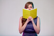 Teacher or smiling  woman adult student holding open yellow book in front of, isolated portrait.