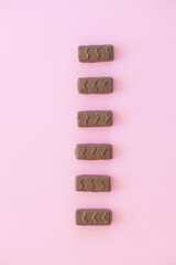 Poster - Chocolate bar with caramel and peanut on pink background.