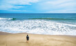 © scaliger - Deserted beach and lone watching man, person stands alone on sea sand shore