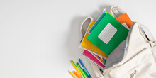 Backpack With Colorful School Supplies On White Background. Back To School. Flat Lay, Top View, Copy Space