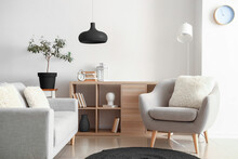 Comfortable Grey Furniture With Wooden Shelving Unit And Black Lamp In Light Living Room