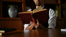 A Professional And Smart Asian Businessman Reading A Book At His Office Desk. Cropped