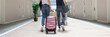 © H_Ko - Couple walking with luggage along the hotel corridor