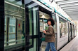 smiling young business woman entering the tram, concept of public transport and urban lifestyle