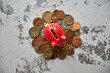 czerwona świnka skarbonka i różne monety 