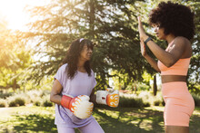 Determined Elderly Woman Practicing Boxing With Daughter In Park