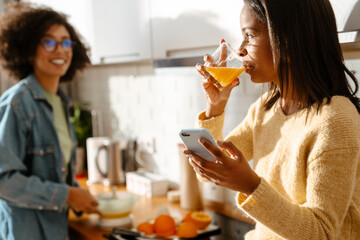 African american woman and daughter making fresh orange juice