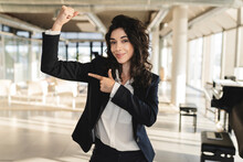Businesswoman Pointing At Muscle In Office