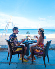 Wall Mural - Breakfast on the beach in Phuket Thailand, a couple of men, and women having a Luxury breakfast table with food and beautiful tropical sea view background., luxury travel and lifestyle. 