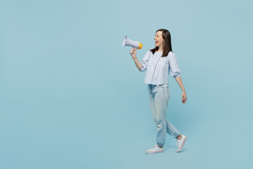 Wall Mural - Full body young happy smiling woman she 20s in casual blouse hold scream in megaphone announces discounts sale Hurry up isolated on pastel plain light blue background studio. People lifestyle concept.