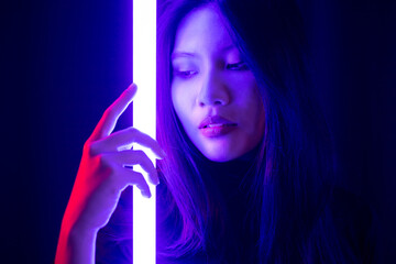 Stylish sexy woman in trendy. Beautiful young asian woman standing pose with neon light. Asia Pretty asian female in the dark room. Fashion shot.