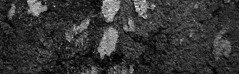 Old cement black grunge wallpaper background. Black stone concrete texture background anthracite panorama. Panorama dark grey black slate background or texture. Concrete wall texture. Dark wallpaper.
