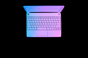 Canvas Print - Creative flat lay with laptop or notebook in vibrant gradient neon colors on black background with copy space. Concept art. Minimal office surrealism.