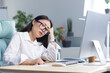 © Liubomir - A sad Asian business woman despairs of her abilities, is depressed and works in the office at the computer.